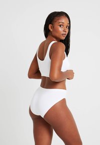 Vit bralette och högmidjade trosor, slätt tyg, minimalistisk design, med breda axelband och sömlös finish.
