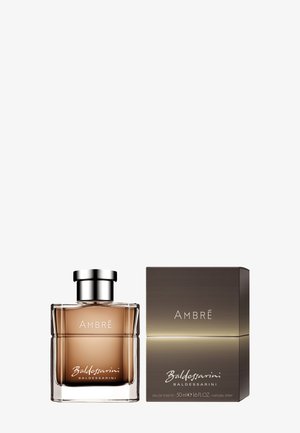 Amber-colored Baldessarini Ambre perfume bottle with silver cap beside matching box with brand and scent name.