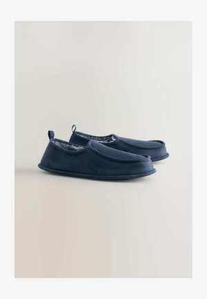 Granatowe klapki wykonane z miękkiego materiału, z teksturowanym wnętrzem, wygodnym designem typu slip-on i małą pętelką z tyłu do łatwego zakładania.