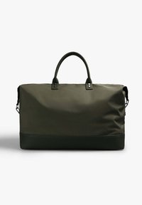 Bolsa de deporte verde oliva hecha de un tejido duradero con una textura suave. Cuenta con dos asas resistentes y una base oscura en contraste.