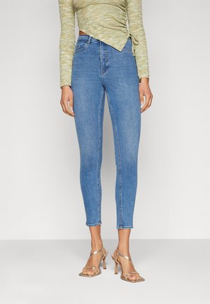 High-waisted blue denim jeans with a slim fit and ankle length, featuring a smooth texture and minimal stitching details.
