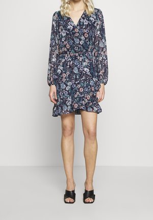 Robe portefeuille florale en bleu marine avec des manches longues, un ourlet volanté et une taille cintrée. Présente un mélange de motifs floraux colorés sur un tissu transparent.
