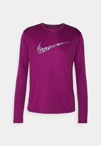 Langärmliges Sportshirt aus vibrierendem lila Stoff mit einem metallisch silbernen Nike-Logo-Design und einem rundem Kragen.
