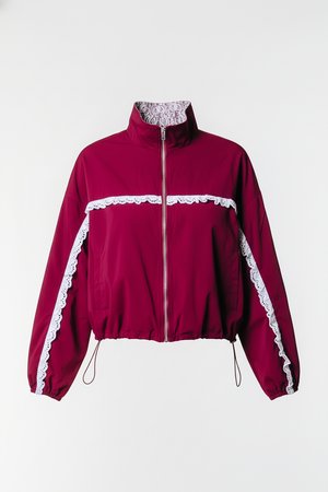 Μπουφάν αδιάβροχο μπορντό με λευκές δαντέλες κατά μήκος του στήθους και των μανικιών, ψηλό γιακά, φερμουάρ μπροστά και ελαστικό τελείωμα και μανσέτες για εφαρμοστή εμφάνιση.