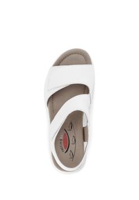 White open-toe sandal with two adjustable straps, soft cushioned insole, and a flexible sole. Features a subtle logo on the footbed.
