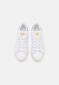 Sneakers bianchi con tomaia in pelle liscia, design con lacci, dettagli perforati e un accento in stampa leopardata sul tallone.