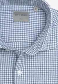 Blå og hvid ternet skjorte med en slim fit, med knap-ned krave, mærkeskilt og en glat stofstruktur. Størrelsesmærkat viser '40'.