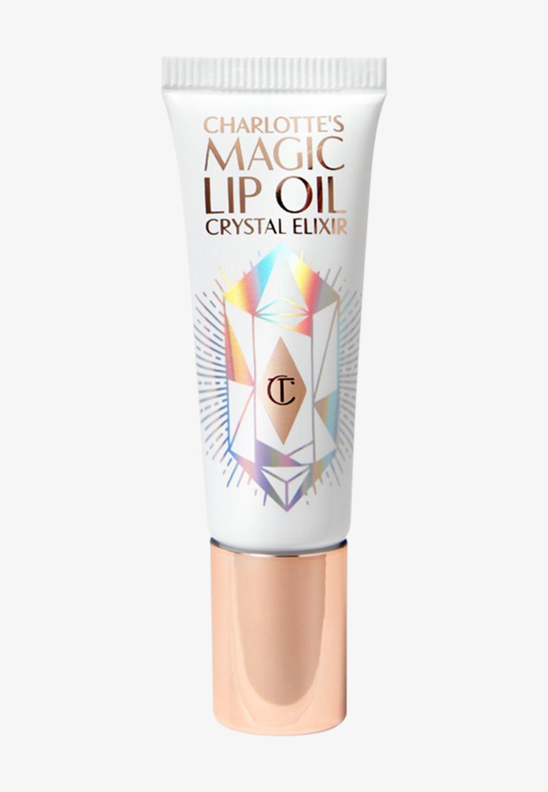 Charlotte's Magic Lip Oil packaging features a white tube with a crystal design, iridescent accents, and a rose gold cap. Text includes brand name and product type.