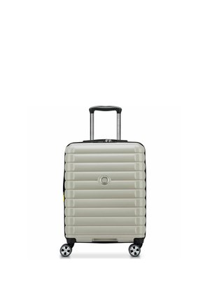 Kleiner silberner Hartschalenkoffer mit horizontalen Rillen, vier Spinnerrollen und schwarzem ausziehbarem Griff.