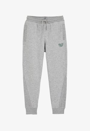 Pantalon de survêtement gris en tissu doux avec poches latérales, ceinture côtelée et texte brodé vert ; présente un panneau latéral texturé.