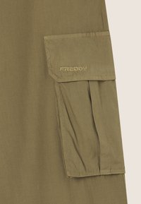 Tessuto verde oliva con una texture liscia, dotato di tasca frontale e logo ricamato "FREDDY". Design semplice e funzionale.