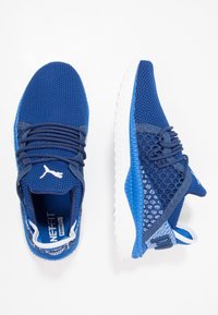 Niebieskie buty sportowe z siateczkowymi cholewkami i teksturowanymi akcentami. Wyposażone w system sznurowania, wyściełany język oraz białe gumowe podeszwy.