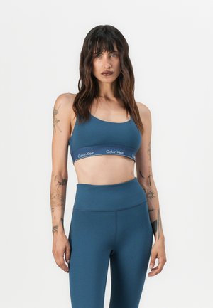 Blauwe sportbeha en hoge taille legging van Calvin Klein, gemaakt van een gladde stof met een logo band en een aansluitend ontwerp.