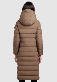 Lang, gevoerde bruine jas met een grote capuchon. Bevat horizontale gestikte secties en een slanke silhouet. Zachte, gladde textuur.