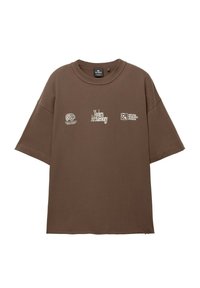Brown oversized t-shirt made of soft cotton. Features white text graphics and logos on the front. Crew neck and short sleeves.