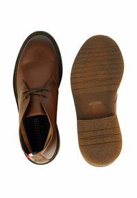 Bruine leren schoenen met een gladde textuur, vetersluiting, ronde neus en rubberen zool met grip patronen. Inclusief een merkembleem aan de binnenkant.