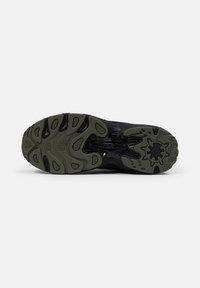 Suola di scarpa sportiva nera con un design testurizzato, realizzata in materiale gomma e con una combinazione di dettagli nero e verde oliva.