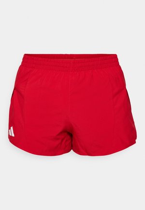 Pantalones cortos deportivos rojos hechos de tejido ligero con una cinturilla elástica. Cuenta con bolsillos laterales y un acento de logo blanco cerca del dobladillo.