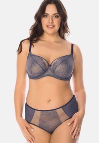 Lace bra and brief set in navy blue featuring semi-sheer mesh panels, floral pattern, adjustable straps, and a central bow accent.