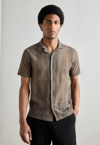 Cămașă din tricot, cu manșete scurte, de culoare maro, cu închidere cu butoane și un model texturat cu linii verticale și detalii asemănătoare dantelei.