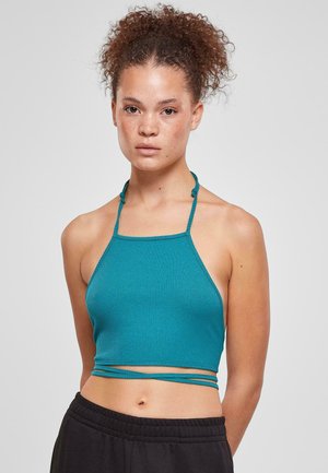 Teal-rippierter Halter-Crop-Top mit dünnen Trägern und schmalem Schnitt. Verfügt über ein gewickeltes Detail auf Taillenhöhe. Der Hintergrund ist ein einheitliches Hellgrau.