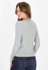 Világosszürke, cable-knit pulóver bordázott mandzsettákkal és aljjal. Kerek nyakkivágással és textúrázott mintázattal az anyagon.