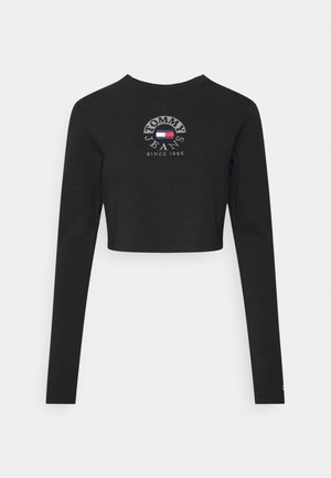 Czarny krótki top z długim rękawem z napisem "Tommy Jeans Since 1985" oraz logo flagi w kolorach czerwonym, białym i niebieskim na piersi.