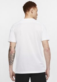 Witte sportshirt met korte mouwen, met een mesh-structuur. Het ontwerp aan de achterkant is eenvoudig met een ronde halslijn en gestikte zoom.