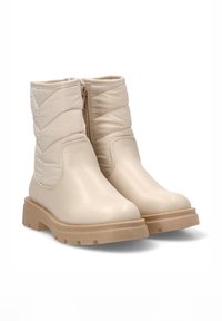 Botas de tobillo beige con un exterior de cuero liso y textil acolchado, que cuentan con un cierre lateral de cremallera y una suela gruesa de goma.