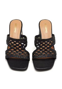Zapatillas de slide tejidas en negro con correas anchas, puntera cuadrada y una suela lisa y mate. Presenta una plantilla con marca en texto dorado.