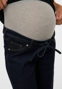 Jeans maternità in denim blu scuro con vita regolabile a cordoncino. Il tessuto visibile è di un grigio morbido, che offre elasticità per il massimo comfort.