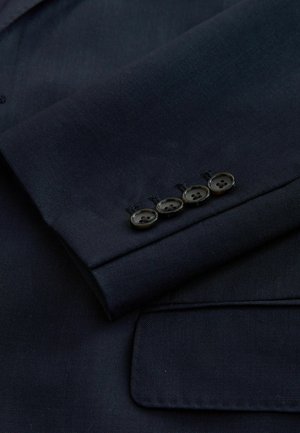 Navy blazer sleeve featuring a lined texture, four black buttons along the cuff, and a classic notch lapel detail.