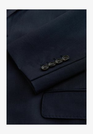 Navy blazer sleeve featuring a lined texture, four black buttons along the cuff, and a classic notch lapel detail.