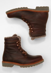 Botas de tobillo de cuero marrón con un acabado texturizado, forro de piel de pelo, ojales de metal y una suela de goma resistente y contrastante.