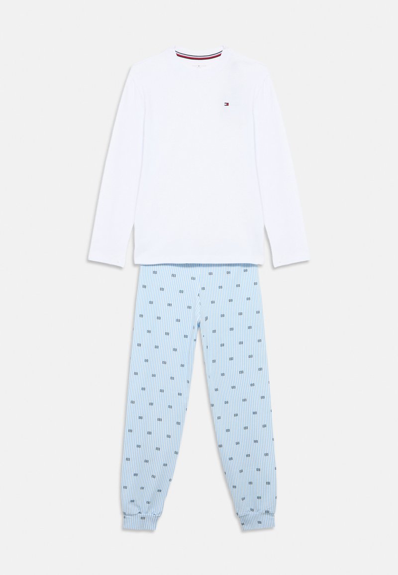 Camiseta blanca de manga larga con cuello de rayas rojas y azul marino, combinada con pantalones azul claro a rayas con un pequeño patrón en azul marino.