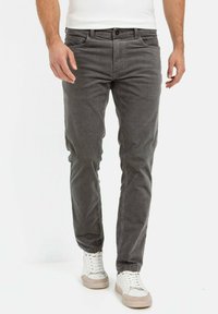 Grijze katoenmix broek met een rechte pasvorm, voorzakken en een ritssluiting. Gepaarde met witte sneakers, met subtiele beige accenten.