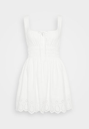 Valge ilma varrukateta kleit ruudu kujulise kaelusega, smockitud rinnaosaga ja lõhenenud silmadega ääre detailidega. Valmistatud kergest kangast.