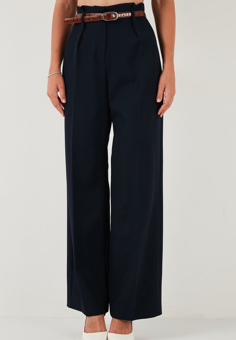 Pantaloni bleumarin cu talie înaltă, cu un design evazat, având o curea maro cu finisaj texturat și o închidere lustruită.