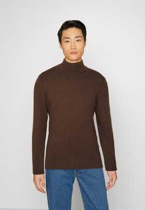 Dunkelbrauner Rollkragenpullover aus weichem Strickmaterial, mit langen Ärmeln und taillierter Silhouette, kombiniert mit blauen Jeans.