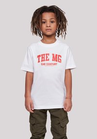Weißes Baumwoll-T-Shirt mit rotem Drucktext "THE MG CAR COMPANY" auf der Vorderseite. Kombiniert mit olivgrünen Cargo-Hosen.