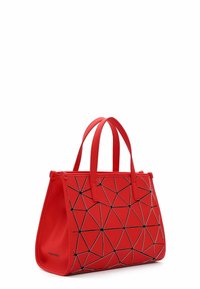 Borsa geometrica rossa con forma strutturata, realizzata in materiale liscio e con accenti triangolari neri e doppio manico superiore.