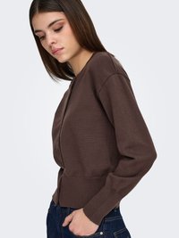 Bruine gebreide cardigan met een aansluitend ontwerp, geribbelde manchetten en zoom. Het heeft een ronde halslijn en een gladde textuur.