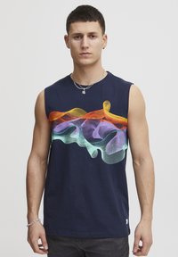 T-shirt senza maniche in cotone blu navy con un design a onde colorato in arancione, viola e verde sul petto. Vestibilità classica, dettagli minimi.