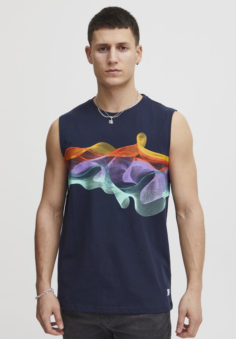 T-shirt senza maniche in cotone blu navy con un design a onde colorato in arancione, viola e verde sul petto. Vestibilità classica, dettagli minimi.