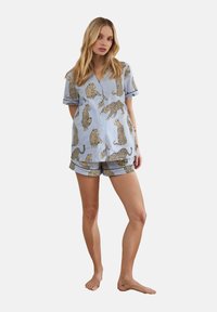Blue striped pajama set featuring a short-sleeve button-up top and matching shorts, adorned with leopard print patterns. Cotton fabric.