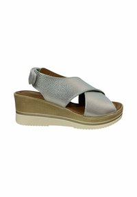 Sandalias de cuña con parte superior de cuero texturizado plateado, diseño de tiras cruzadas y una suela de plataforma beige con dibujo para mayor agarre.