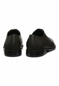 Scarpe in pelle nera con tacco texturizzato e finitura liscia, caratterizzate da una punta rotonda e suola bassa.