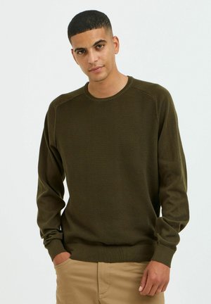 Maglione a maglia verde oliva con colletto rotondo e polsini a coste. Presenta un motivo testurizzato e maniche raglan per una vestibilità rilassata.