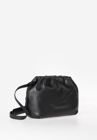 Borsa a spalla in pelle nera con parte superiore arricciata, superficie testurizzata, chiusura con zip e tracolla rimovibile. Design compatto adatto per gli essenziali.