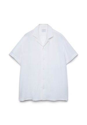 Chemise blanche à manches courtes avec boutons, tissu texturé et col à pointes étalées, présentée sur un fond blanc uni.